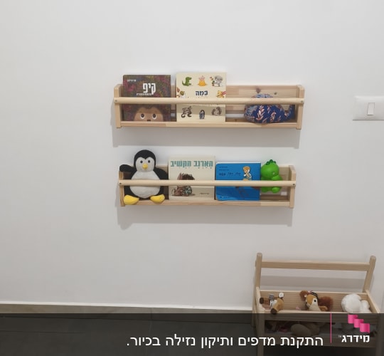 מדפים עם ספרים וצעצועים על קיר לבן